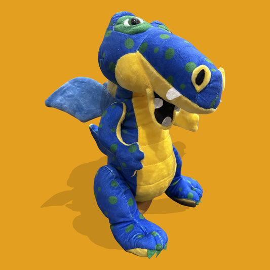 Blue and yellow plush dragon toy on an orange background